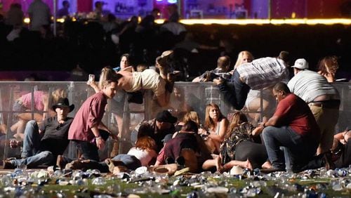 People scramble for shelter after a gunman opened fire at a music festival in Las Vegas. Wire photo.
