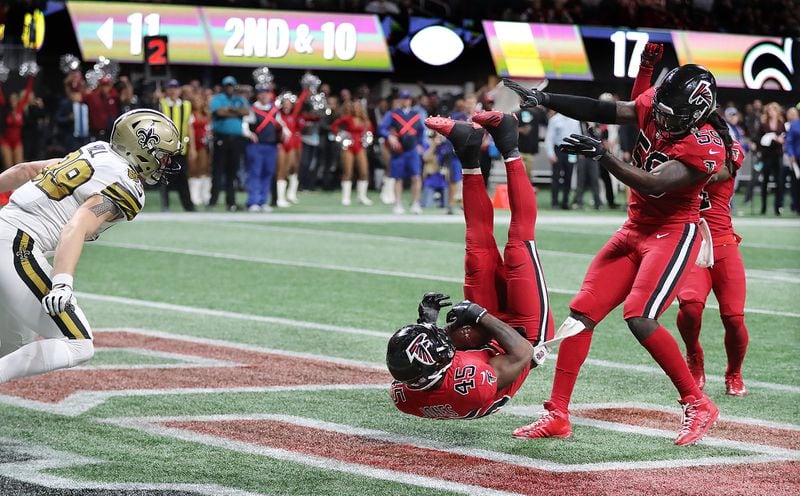 Deion Jones lands with a game-clinching, endzone interception of the Saints Drew Brees in 2017. Guess who that Falcon is next to him?  (Curtis Compton/ccompton@ajc.com)