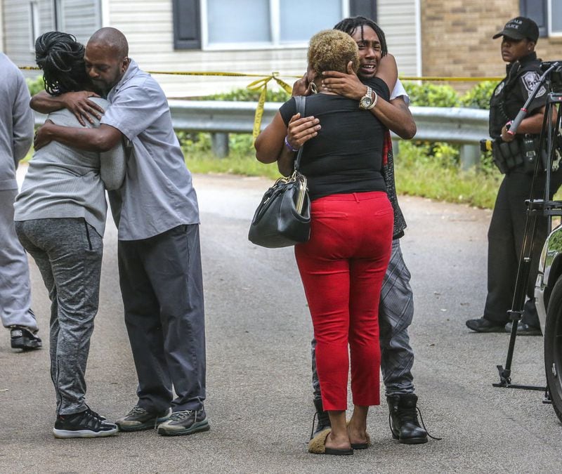 Friends and family grieve at the scene where three people in their 20s were found shot to death in a DeKalb County apartment the morning of August 30, 2017. JOHN SPINK/JSPINK@AJC.COM