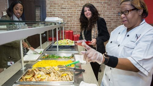 (left to right, all cq) Kelsey Darren & food service director Carol Cottrell listen to Kimberly Spear describe the lunch choices at Woodward Academy in Atlanta on January 30th, 2017. Woodward is the large employer AJC Top Workplace winner. (Photo by Phil Skinner)