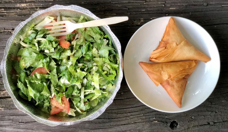 This takeout order from Tigi’s Cafe & Food Truck in Stone Mountain includes a salad of cabbage, tomatoes, onions and peppers; and a pair of crispy sambusas (one vegan, one chicken). CONTRIBUTED BY WENDELL BROCK

