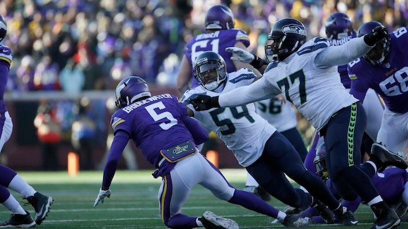 Minnesota Vikings quarterback Teddy Bridgewater (5) is brought down by Seattle Seahawks linebacker Bobby Wagner (54) and defensive tackle Ahtyba Rubin (77) during the second half of an NFL wild-card football game, Sunday, Jan. 10, 2016, in Minneapolis. (AP Photo/Nam Y. Huh)