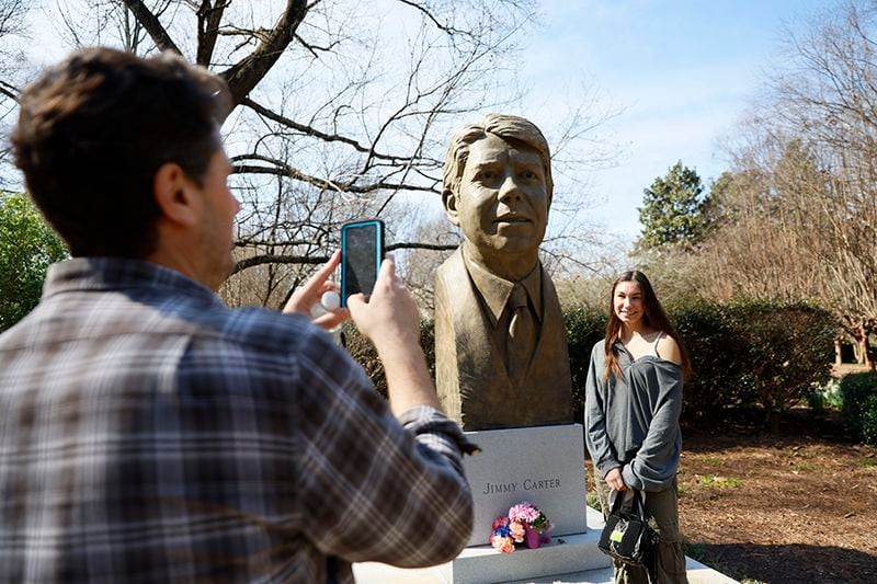 Jon Freedman from New York takes a photo of his daughter Daniella Freedman in front of the bust of Jimmy Carter on Monday, Feb 20, 2023. They're in Georgia visiting colleges for Danielle. (miguel.martinezjimenez@ajc.com)