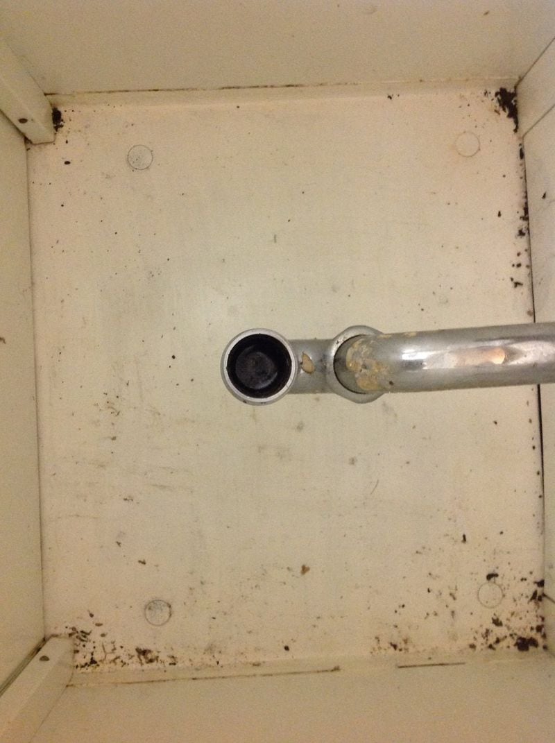 Water pools in the severed drain pipe of a damaged sink near the operating room at Augusta State Medical Prison.