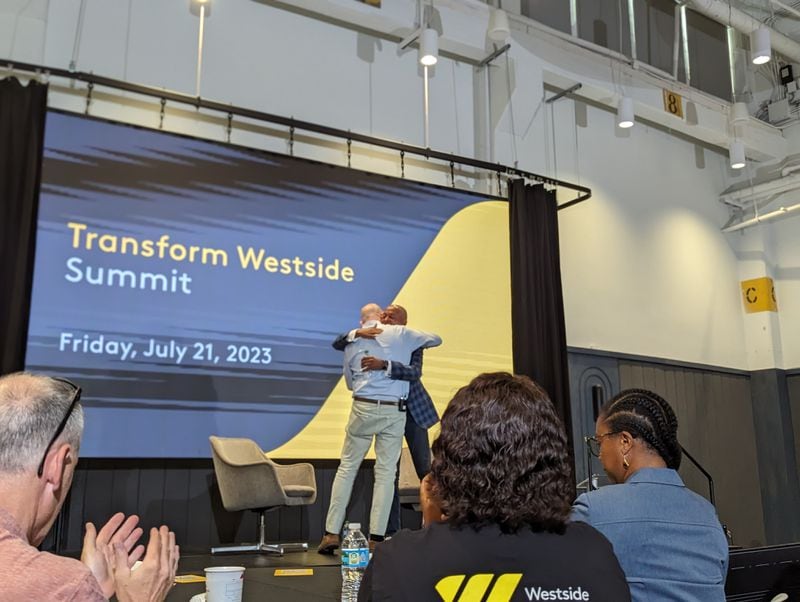 John Ahmann, president and CEO of the Westside Future Fund, and Dallas Smith, founder and CEO of T. Dallas Smith & Company and chair-elect of the Westside Future Fund board, embrace after the Transform Westside Summit on July 21, 2023.
