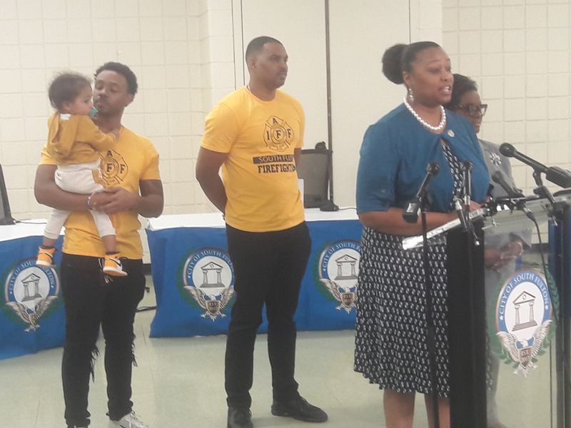 South Fulton Councilwoman Natasha Williams speaks Tuesday against allegations of a hostile work environment made by City Manager Tammi Saddler Jones. Councilwoman Helen Willis stands next to Williams. Members of the city firefighters' union stand behind them in yellow T-shirts.