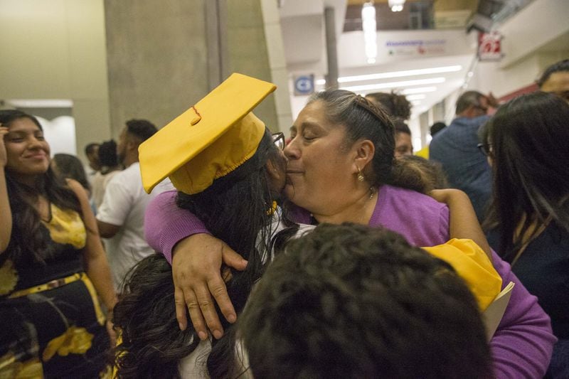 Marisela Lozada receives a kiss from her relative, Honoria Ramirez, after her graduation ceremony. ALYSSA POINTER/ATLANTA JOURNAL-CONSTITUTION
