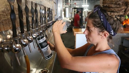 A Creature Comforts Brewing Company employee fills a 32-oz. crowler for a customer to take home Aug. 27 in Athens. (AJC Photo / Curtis Compton)