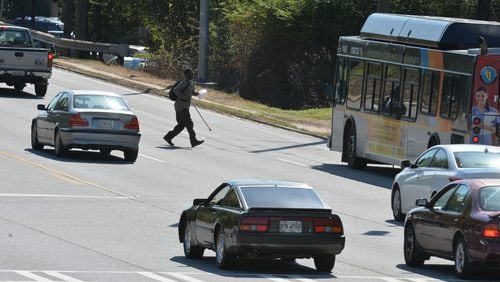 A pedestrian crosses Buford Highway to catch a MARTA bus near Clairmont Road. Buford Highway is No. 2 on the list of the most dangerous roads for pedestrians in metro Atlanta.