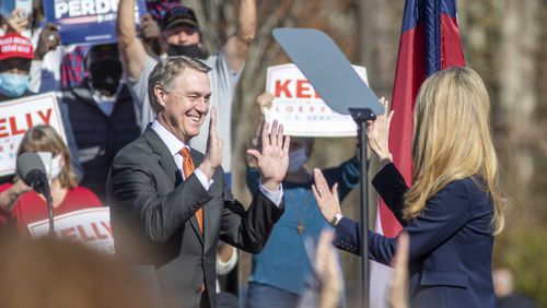 11/20/2020 �  Canton, Georgia �Senator David Perdue (left) and Senator Kelly Loeffler (right) exchange a high-five as they take turns speaking to the crowd gathered during a Defend the Majority Republican Rally in Canton, Ga., Friday, November 20, 2020.  (Alyssa Pointer / Alyssa.Pointer@ajc.com)