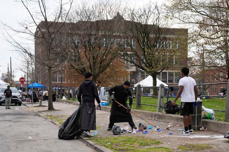 People clean up debris at the scene of a shooting at an Eid al-Fitr event in Philadelphia, Wednesday, April 10, 2024. (AP Photo/Matt Rourke)