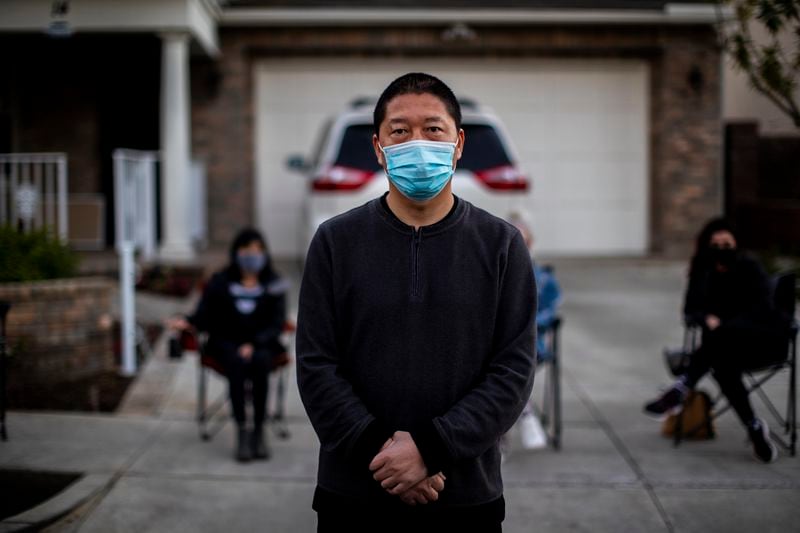 Haijun Si stands in front of his home in Ladera Ranch, California, as neighbors form a nightly security detail to deter teens who have harassed his family by throwing rocks and yelling racial slurs.