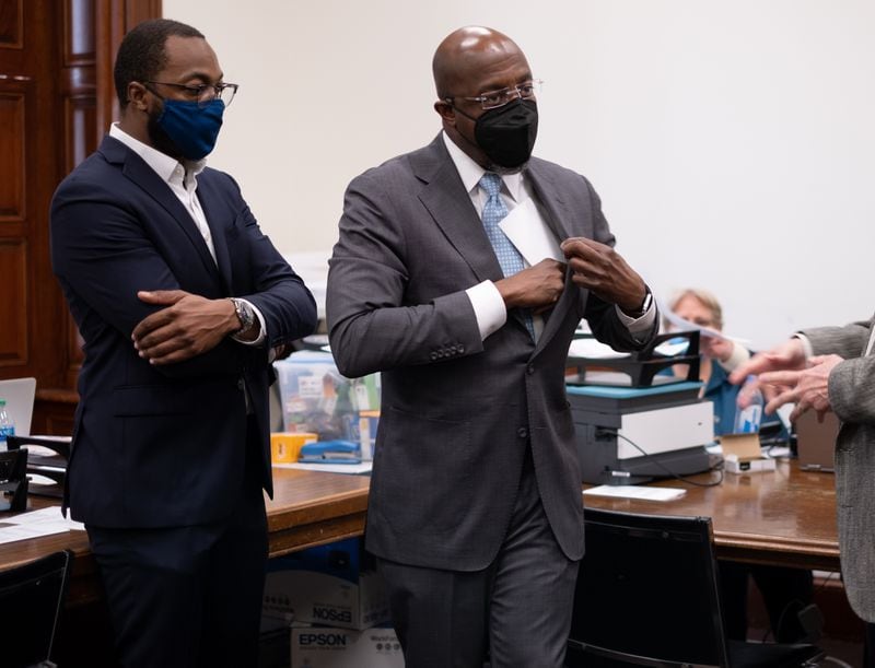 Democratic U.S. Sen. Raphael Warnock tucks paperwork into his jacket pocket Monday, shortly after he became among the first candidates to qualify for this year's elections. Ben Gray for the Atlanta Journal-Constitution
