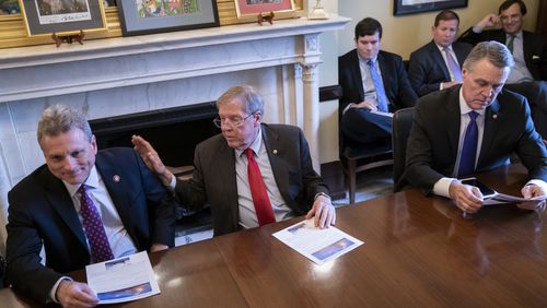 Sen. Johnny Isakson, R-Ga., flanked by Rep. Buddy Carter R-Ga., left, and Sen. David Perdue, R-Ga., right, leads a meeting with the Georgia Ports Authority and the Army Corps of Engineers about the budget for the Savannah Harbor Expansion Project  on Feb. 14, 2019. (AP Photo/J. Scott Applewhite)