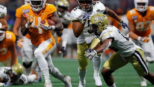 ATLANTA, GA - SEPTEMBER 04:  John Kelly #4 of the Tennessee Volunteers rushes against Corey Griffin #14 and A.J. Gray #5 of the Georgia Tech Yellow Jackets at Mercedes-Benz Stadium on September 4, 2017 in Atlanta, Georgia.  (Photo by Kevin C. Cox/Getty Images)