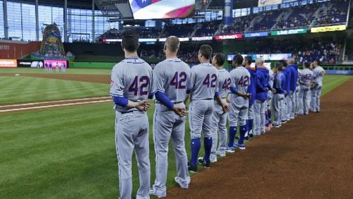 New York Mets players, wearing the number 42, stand during the singing of the National Anthem before the start of a baseball game against the New York Mets, Saturday, April 15, 2017, in Miami. Every Major League player wore the number 42 Saturday, to honor Jackie Robinson.