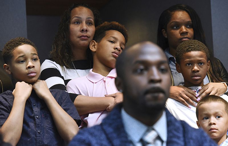 Marcus Riley of Bolingbrook, Illinois, speaks during a news conference Nov. 5 in Aurora about how he and other families, shown in the background, were asked to move because others didn't want to sit by them at a Naperville Buffalo Wild Wings.