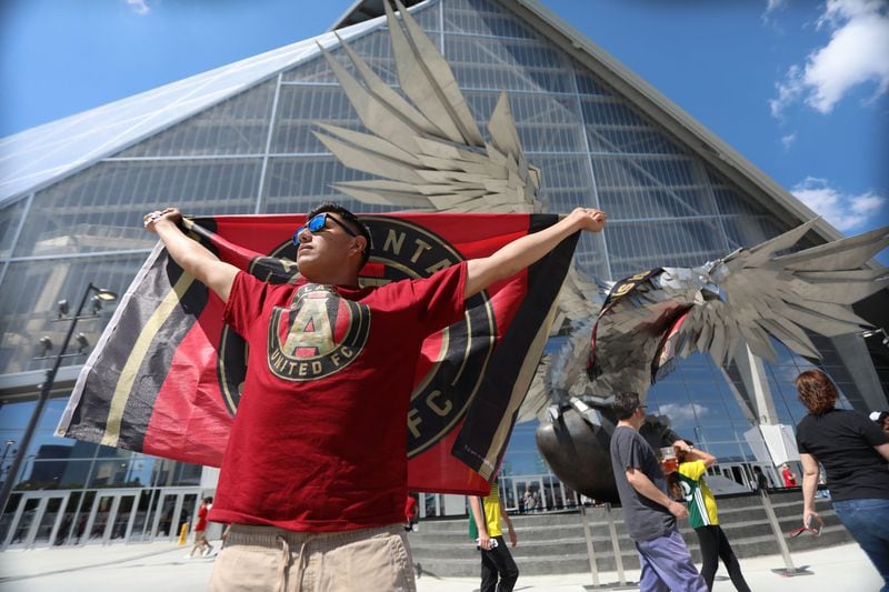 Manuel Garcia from Asheville North Carolina shows his support with the Atlanta United flag in front of  the Mercedes-Benz Stadium in Atlanta, Georgia, Saturday, April 28, 2018.