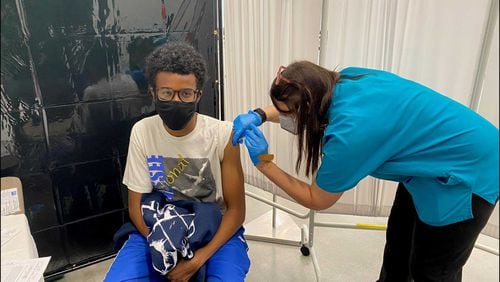 Georgia Tech nurse Melanie Thomas administers a COVID-19 vaccine shot to student Grayson Prince at its Exhibition Hall on July 20, 2021. The school has been doing vaccinations on Tuesdays this summer for students and employees. (Eric Stirgus / estirgus@ajc.com)