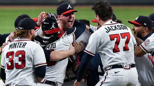 Braves pitcher Will Smith is mobbed by fellow Braves after he struck out Milwaukee Brewers left fielder Christian Yelich (22) to end Game 4 of the NLDS Wednesday, Oct. 12, 2021, at Truist Park and advance Atlanta to the league championship series. (Hyosub Shin / Hyosub.Shin@ajc.com)
