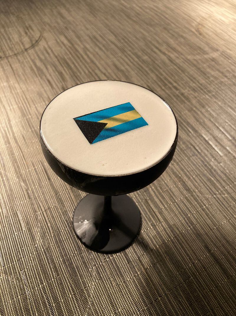 An edible rice paper Bahamian flag rests atop the Caribbean Soul cocktail at Atlas. Courtesy of Atlas