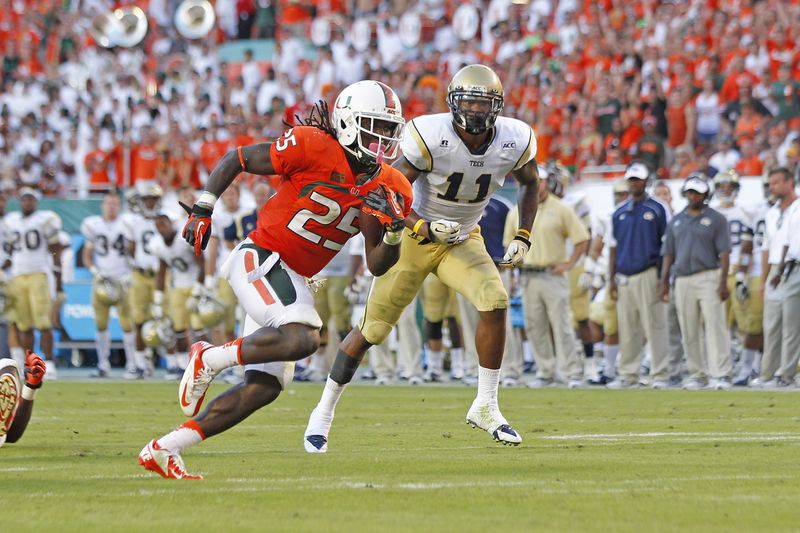 MIAMI GARDENS, FL - OCTOBER 5: Brandon Watts #11 of the Georgia Tech Yellow Jackets is unable to defend Dallas Crawford #25 of the Miami Hurricanes as he runs 17 yards for a fourth quarter touchdown on October 5, 2013 at Sun Life Stadium in Miami Gardens, Florida. The Hurricanes defeated the Yellow Jackets 45-30. (Photo by Joel Auerbach/Getty Images)