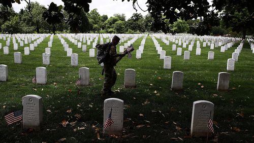 ARLINGTON, VA: Members of the U.S. Army’s 3rd Infantry Regiment place flags at the headstones of U.S. military personnel buried at Arlington National Cemetery, in preparation for Memorial Day in Arlington, Virginia. (Photo by Win McNamee/Getty Images)