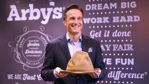Arby’s CEO Paul Brown, holding a hat Pharrell Williams wore during the 2014 Grammy Awards, says playful products and marketing have paid off for the Atlanta fast-food chain. The hat, which Arby’s bought for $49,000, resembles Arby’s logo. Curtis Compton/ccompton@ajc.com