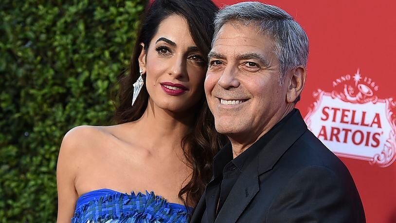 FILE - In this Oct. 22, 2017 file photo, Amal Clooney and George Clooney arrive at the premiere of "Suburbicon" in Los Angeles. George and Amal Clooney are donating $500,000 to students organizing nationwide marches against gun violence, and they say theyll also attend next months planned protests. In a statement released Tuesday, Feb. 20, the couple says they are inspired by the courage and eloquence of the survivors-turned-activists from Stoneman Douglas High School in Parkland, Fla. (Photo by Jordan Strauss/Invision/AP, File)