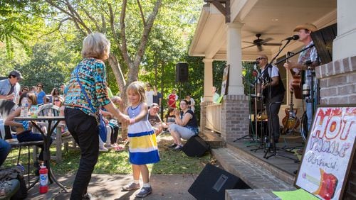 Hot Tamale Ringwald gets Chandler Campos of Sandy Springs, and her grandmother Cecy Compos of Alpharetta, on their feet and dancing at Porchfest in Oakhurst. (Photo by JENNI GIRTMAN)