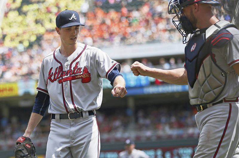 Braves' pitcher Max Fried, left, gets a fist bump from catcher Tyler Flowers after Minnesota Twins' catcher Mitch Garver flew out to end the fifth inning. (AP Photo/Jim Mone)