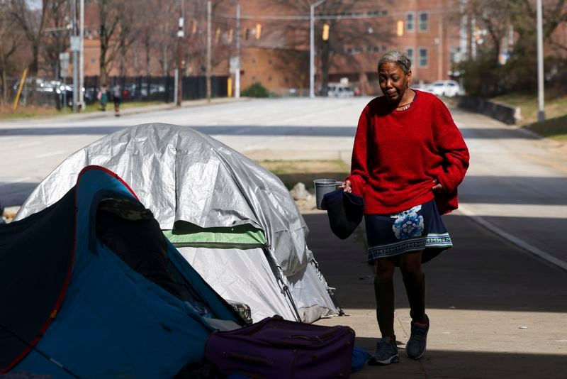 Kimberly Rose Tisby, 51, walks back to her tent at a homeless encampment at Pryor Street under the I-20 overpass, Thursday, February 22, 2024, in Atlanta. (Jason Getz / jason.getz@ajc.com)
