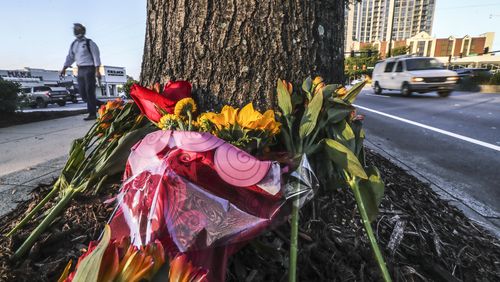 October 13, 2021 Atlanta: A memorial of flowers is growing outside Havertys Furniture located at 3255 Peachtree Road in Buckhead on Wednesday, Oct. 13, 2021 after a woman died within hours of tumbling out of a moving car in Buckhead late Sunday, and police are working to determine if she was pushed from it. The woman was found unconscious on the pavement in the intersection of Piedmont and Peachtree roads about 11 p.m., Atlanta police said in a statement. She was rushed to a hospital but died of her injuries. “Preliminary investigation indicated that the victim may have been pushed or may have fallen from a moving vehicle,” the statement said. Police said the car sped away from the scene, leaving her behind. It has not been located. While officers were initially called to the scene on a report of a person being hit by a car, it is not clear if such a crash resulted in the woman’s death. An investigation is ongoing. (John Spink / John.Spink@ajc.com)
