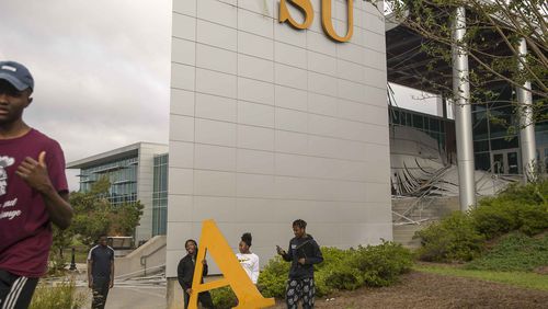 10/11/2018 -- Albany, Georgia -- Students at Albany State University take photographs with a decorative letter that fell off the student center building on the main campus in Albany, Thursday, October 11, 2018. Parts of the campus were destroyed due to Hurricane Michael. (ALYSSA POINTER/ALYSSA.POINTER@AJC.COM)