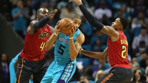 Nicolas Batum of the Hornets is trapped by Hawks’ Paul Millsap (4) and Kent Bazemore (24) during a game last season. (Photo by Streeter Lecka/Getty Images)