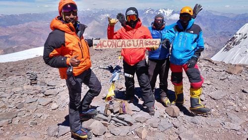 Jermaine Middleton, 31, of Austell (holding sign) reached the top of Mount Aconcagua on Feb. 28. The mountain in Argentina is the highest peak in the Western Hemisphere and is the second highest of the Seven Summits. This spring, Middleton hopes to become the first American-born black man to scale Mount Everest. CONTRIBUTED BY JERMAINE MIDDLETON