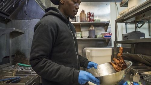 Line cook Royree Collins prepares smoked chicken wings at Fox Bros. Bar-B-Q near Atlanta’s Little Five Points community. They expect to sell roughly 18,000 wings on game day at that location. ALYSSA POINTER / ALYSSA.POINTER@AJC.COM