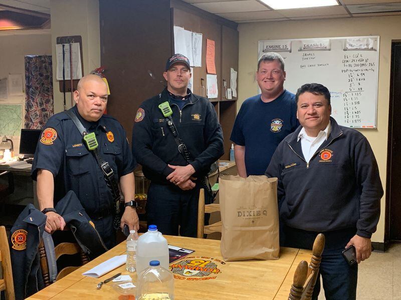 Firefighters at DeKalb-Peachtree Airport receive a meal from Dixie Q that was paid for by a group of neighbors in Brookhaven. Courtesy of Matt Gunter