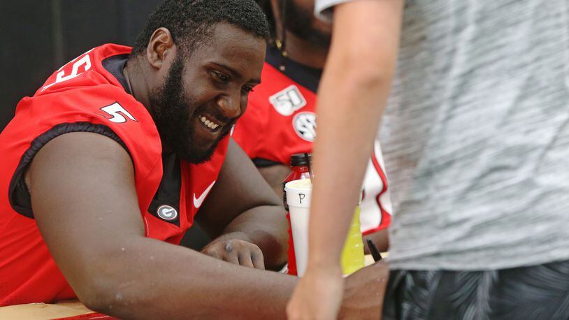 August 3, 2019 Athens-  University of Georgia Julian Rochester smiles and signs posters during UGA Fan Day at the team's indoor practice facility in Athens, Georgia on Saturday, August 3, 2019. Fans came out in force to get posters autographed by their favorite players before the beginning of the 2019 season. Christina Matacotta/Christina.Matacotta@ajc.com