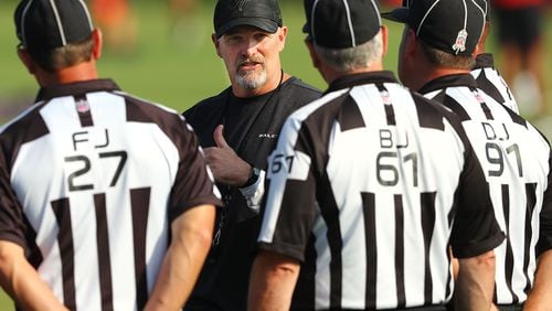 Falcons head coach Dan Quinn has a discussion with NFL officials during team practice on Monday, July 29, 2019, in Flowery Branch.   Curtis Compton/ccompton@ajc.com