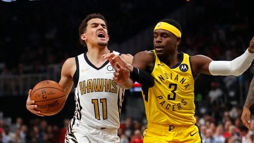 Hawks guard Trae Young is fouled by Pacers guard Aaron Holiday. The two now are teammates with the Hawks. (AP Photo/John Bazemore)
