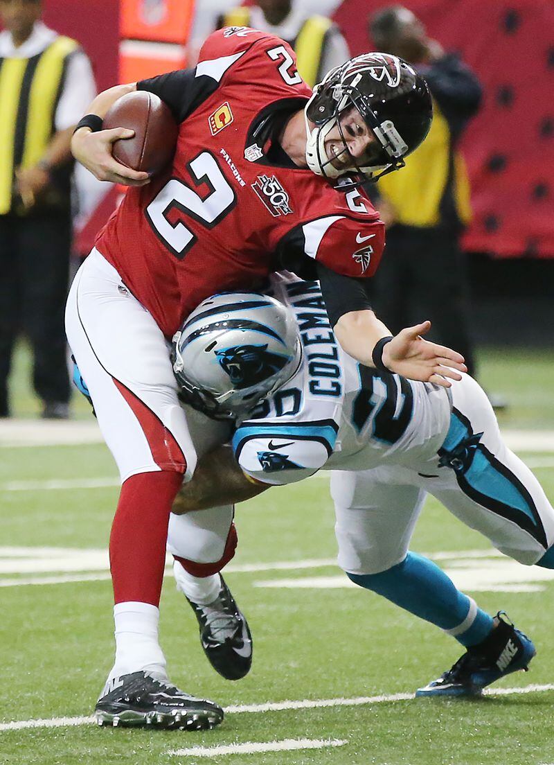 122815 ATLANTA: Falcons quarterback Matt Ryan takes a hard hit from Panthers safety Kurt Coleman as he runs for a first down on a quarterback keeper during the first half in a football game on Sunday, Dec. 27, 2015, in Atlanta. The Falcons beat the Panthers 20-13 to end their perfect season. Curtis Compton / ccompton@ajc.com
