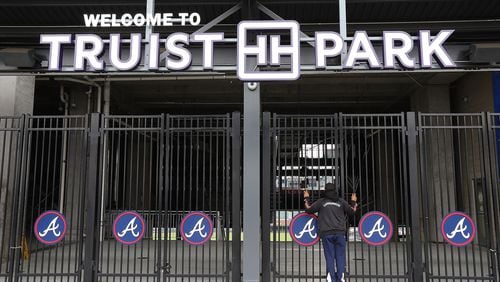During a visit to the Battery Atlanta baseball fan Dwayne Jones pauses to take a look through the gates at the Atlanta Braves newly renamed Truist Park after new signage has been installed waiting for the delayed start of baseball season in the wake of the coronavirus on Monday, March 16, 2020, in Atlanta.   Curtis Compton ccompton@ajc.com