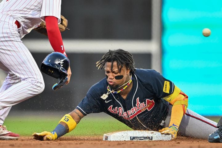 Atlanta Braves’ Ronald Acuna Jr. (13) slides safely into second base on a double ahead of the throw to Philadelphia Phillies shortstop Trea Turner during the third inning of NLDS Game 3 in Philadelphia on Wednesday, Oct. 11, 2023.   (Hyosub Shin / Hyosub.Shin@ajc.com)