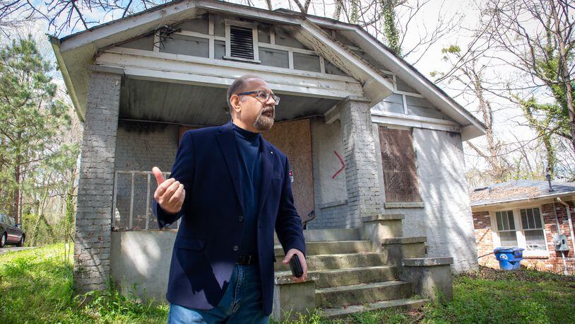 Swapan Kumar stands in front of a house he owns in southwest Atlanta home that the city has marked for demolition Friday, March 25, 2022.  STEVE SCHAEFER FOR THE ATLANTA JOURNAL-CONSTITUTION