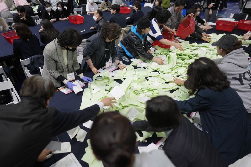 National Election Commission officials sort out ballots for counting at the parliamentary election in Seoul, South Korea, Wednesday, April 10, 2024. (AP Photo/Lee Jin-man)