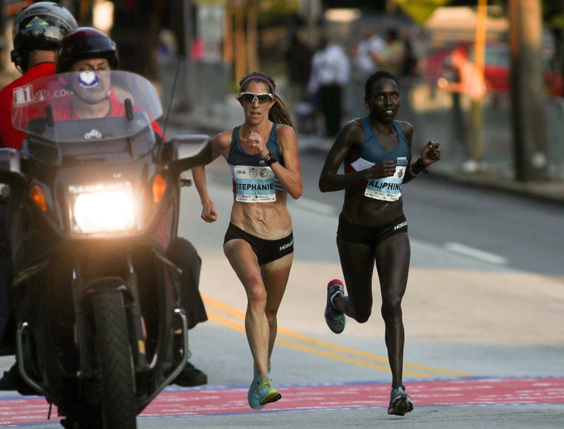 Stephanie Bruce, age 34, and Aliphine Tuliamuk, 29, keep pace near the 5.86 mile marker. Bruce came in first among the elite womens division. Tuliamuk came in second.