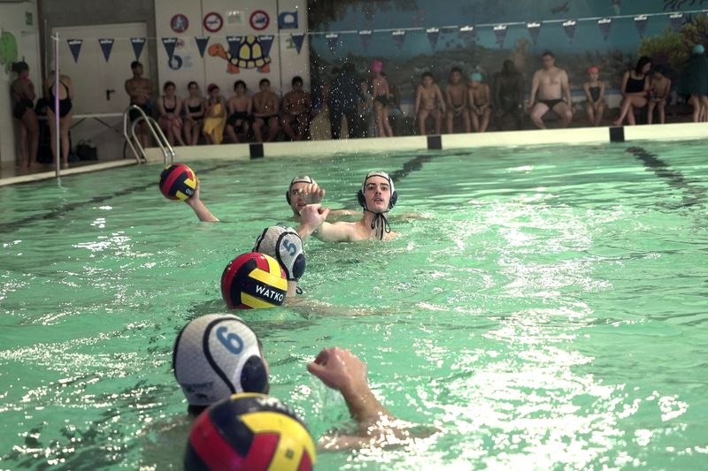 Competitors play water polo at the public swimming pool in the Paris-region town of Sevran, Wednesday, Jan. 24, 2024. The town of 51,000 people in the Seine-Saint-Denis region north of Paris is inheriting one of the pools that will be used for the Olympic and Paralympic Games in Paris this summer. The 50-meter pool Olympic pool for Sevran will be a significant upgrade. Its existing 25-meter pool is nearly 50 years old. (AP Photo/John Leicester)