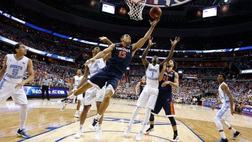 Virginia guard Malcolm Brogdon shoots in front of North Carolina guard Marcus Paige, forward Isaiah Hicks and forward Theo Pinson during the second half of the ACC final Saturday, March 12, 2016, in Washington, D.C. North Carolina defeated Virginia 61-57. (AP Photo/Alex Brandon)