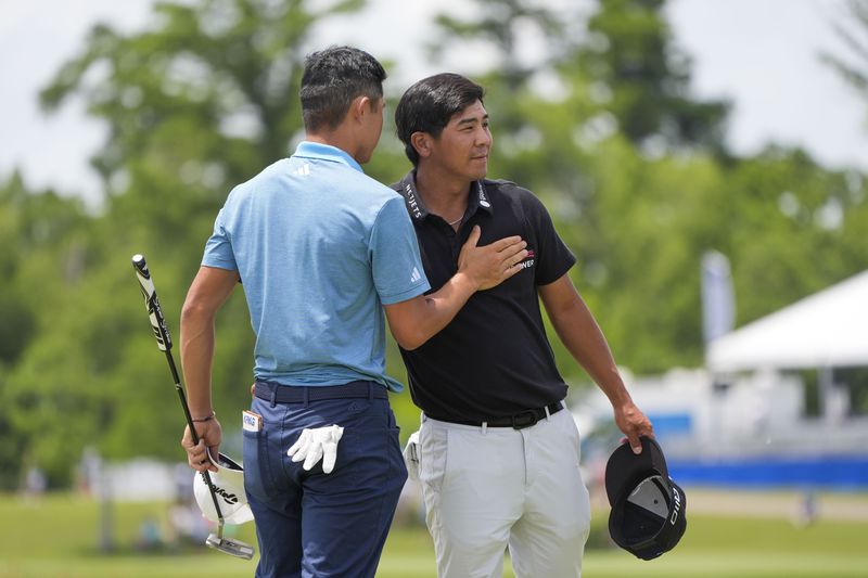 Collin Morikawa congratulates teammate Kurt Kitayama, right, after they finished the day on the ninth green during the second round of the PGA Zurich Classic golf tournament at TPC Louisiana in Avondale, La., Friday, April 26, 2024. (AP Photo/Gerald Herbert)